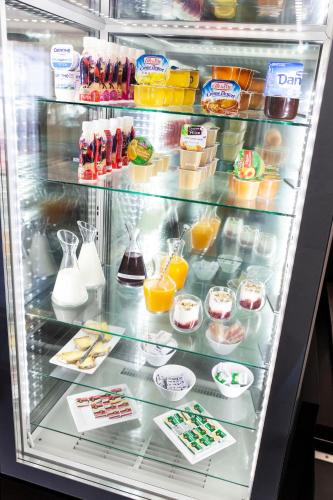 ein Kühlschrank gefüllt mit vielen Lebensmitteln und Getränken in der Unterkunft Hotel Du Golf in Saint-Étienne