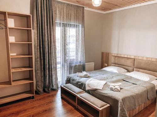 a bedroom with a bed and a large window at Hotel panorama svaneti in Mestia