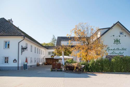 a building with a table and an umbrella in a street at Bierhotel Ranklleiten Almtal in Pettenbach