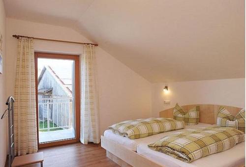 a bedroom with a bed and a large window at Exenbacher Hof in Arnbruck