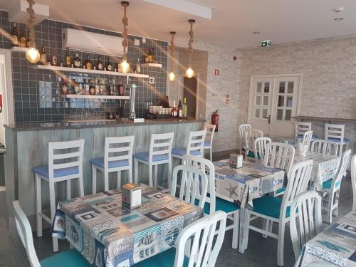 a restaurant with tables and chairs and a bar at See U Inn in Torreira