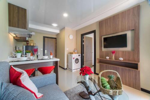 un soggiorno con divano e TV di Квартира вид на бассейн NBC S402 by IBG Property a Nai Harn Beach