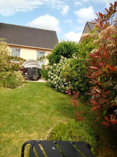 un jardín con una casa y algunos arbustos en chambre moderne en campagne en Le Calvaire