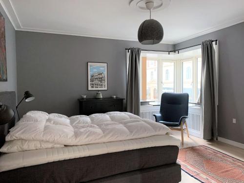 una camera con un grande letto bianco e una sedia di ApartmentInCopenhagen Apartment 1423 a Copenaghen
