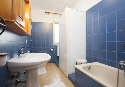 a blue tiled bathroom with a sink and a bath tub at Sole&Luna in San Teodoro