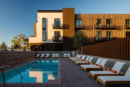 a pool with lounge chairs next to a building at Hotel San Luis Obispo in San Luis Obispo