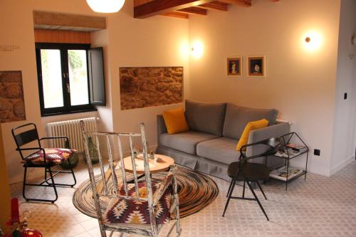 Lugar das Marías في Jove: غرفة معيشة مع أريكة وطاولة وكراسي