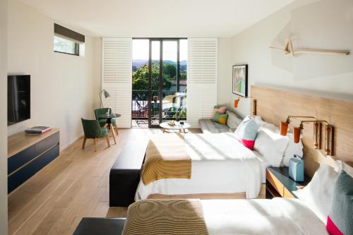 a bedroom with two beds and a living room at Hotel San Luis Obispo in San Luis Obispo