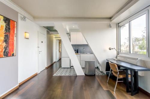 uma sala de estar em plano aberto com uma mesa e uma cozinha em La Muette Terrasse vue Tour Eiffel em Paris