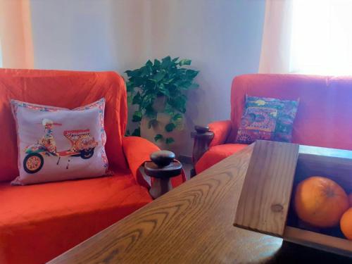 uma sala de estar com um sofá laranja e uma mesa em Nonna Sicilia B&B em Capri Leone