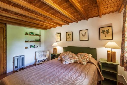 a bedroom with a bed and a wooden ceiling at Casa da Cascata in Furnas