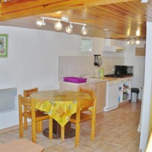 une cuisine avec une table et des chaises dans une pièce dans l'établissement Gîte la grange au cœur de la Provence, à Chaffaut-Lagremuse