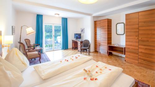 a hotel room with two beds and a desk at Strandhotel Klopeinersee in Sankt Kanzian