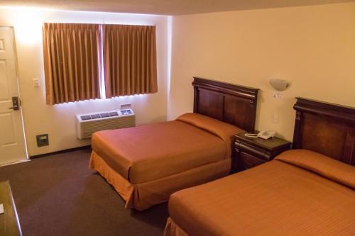 a hotel room with two beds and a window at BONITTO INN® Altamira Zona Industrial in Altamira