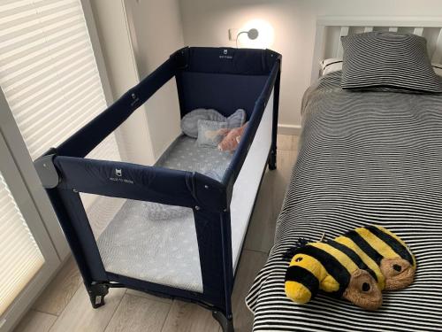 a baby crib with a stuffed animal on a bed at Weiße Düne Ferienwohnung *Weiße Düne 9 / Gen Norden* in Wittdün