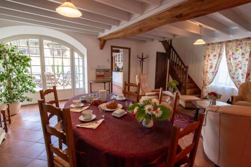 a living room with a dining table and a living room at Au Temps Retrouvé in Courcelles