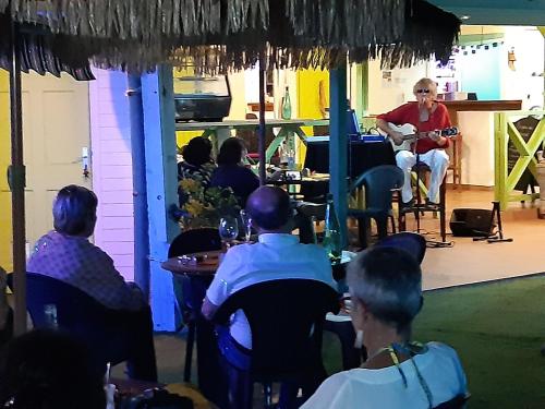 a group of people sitting at tables in a restaurant at La Rose du Bresil Marie-Galante in Capesterre-de-Marie-Galante