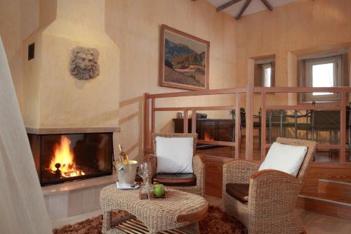 a living room with a fireplace and wicker chairs at Château d'Adomenil in Rehainviller