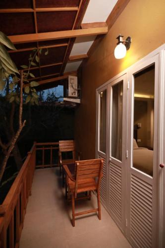 a porch with two wooden benches and a bed at GoGo Land Resort & Adventurous Sports in Pūvār