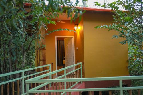 a yellow house with a staircase leading to a door at GoGo Land Resort & Adventurous Sports in Pūvār