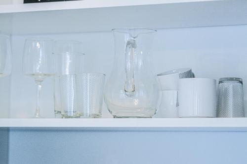 a shelf with glasses and a vase on it at Il Mare appart hotel 1,2,4 in Luxembourg