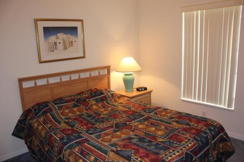 een slaapkamer met een bed, een lamp en een raam bij Villa Mourik in Inverness