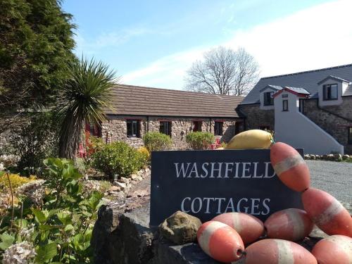 a sign in front of a house with some baseball at Milking Shed Cottage in Narberth