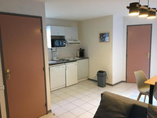a small kitchen with a table and a microwave at Appartement Solférino in Luz-Saint-Sauveur