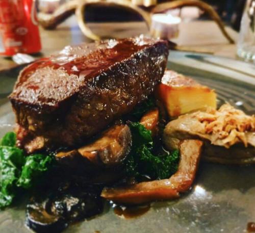 a plate of food with meat and vegetables on a table at The Tormaukin in Glendevon