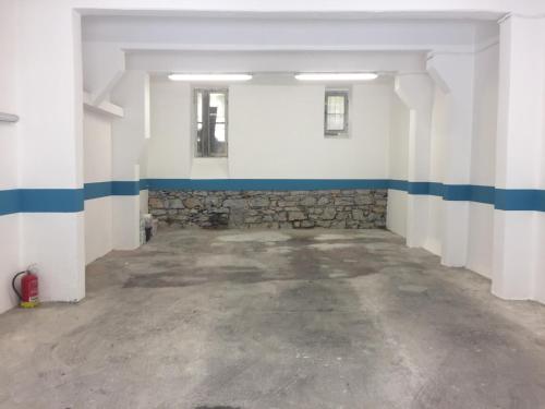 ein leeres Zimmer mit blauen und weißen Wänden und einer Steinmauer in der Unterkunft Echi del Mare in La Spezia