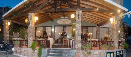 a restaurant with tables and chairs and a clock at Jimmy's Pelekas in Pelekas