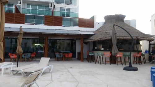 an outdoor patio with chairs and tables and umbrellas at Cancun, Ocean Dream, Beautiful Aparment, Heart of the Hotel Zone in Cancún