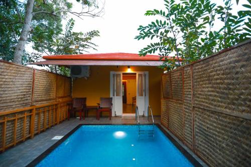 a swimming pool in front of a house at GoGo Land Resort & Adventurous Sports in Pūvār