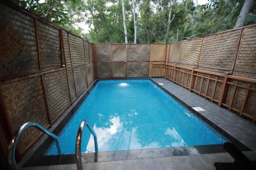 an outdoor swimming pool with a wooden fence at GoGo Land Resort & Adventurous Sports in Pūvār