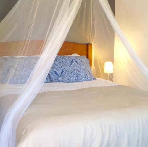 a bed with mosquito netting over the top of it at Verdemar in Cercal
