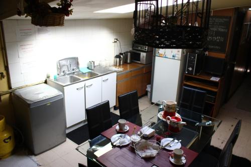 HOSTAL COLLAO في كونثبثيون: مطبخ مع طاولة ومطبخ مع حوض