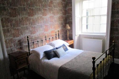 a bedroom with a bed and a brick wall at COOKS CABIN in Plymouth