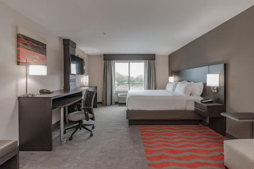 a hotel room with a bed and a desk and a computer at Holiday Inn Mishawaka by IHG in Mishawaka