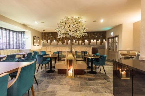 een restaurant met tafels en stoelen en een kroonluchter bij White Lion Hotel in Crewe