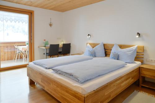 a bedroom with a large bed with blue pillows at Pension Haus Romy in Schoppernau