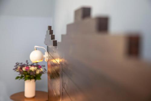 a lamp and a vase with flowers on a table at Fuglsang Herregaard Hotel in Nykøbing Falster