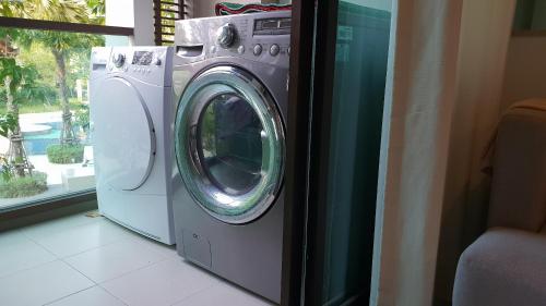a washer and dryer in a room with a window at LPN Cha-am Beachfront Wifi 10 meters to beach 1BR ติดทะเล in Cha Am