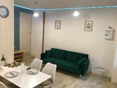 een woonkamer met een groene bank en een tafel bij Résidence Le Musoir in Le Tréport