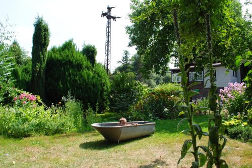 a person sitting in a bath tub in a garden at Agroturystyka Nad Bobrem in Pilchowice