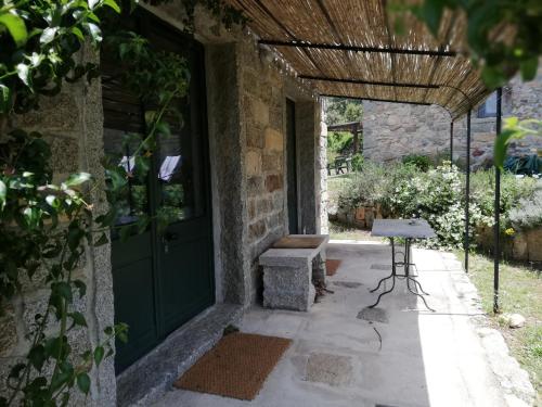an entrance to a house with a green door and a table at Stazzo La Casedda in Luogosanto