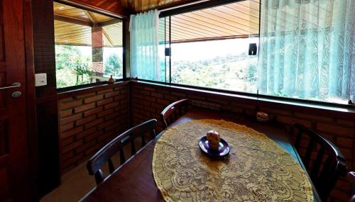d'une salle à manger avec une table, des chaises et une fenêtre. dans l'établissement Casa do Índio, à Visconde de Mauá