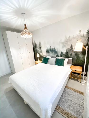 a bedroom with a large white bed with a painting on the wall at Ostoja Bukowinki - Peniński Las in Jaworki