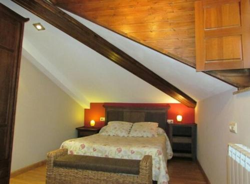 a bedroom with a bed and a couch in a attic at APARTAMENTOS RURALES EL PRIVILEGIO in La Plaza