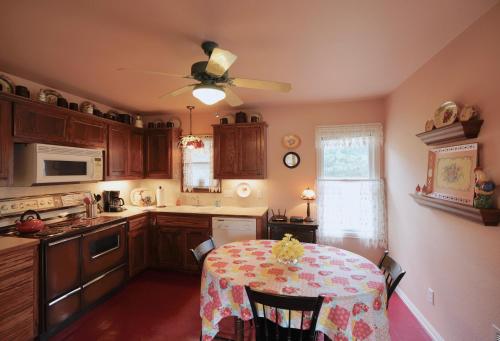 a kitchen with a table and a ceiling fan at Onion Creek Cottage in Austin