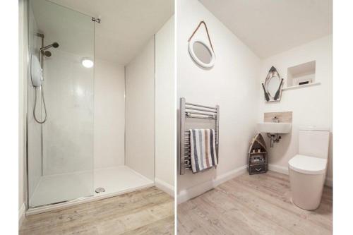 een witte badkamer met een douche en een toilet bij Imperial Apartment in Oban